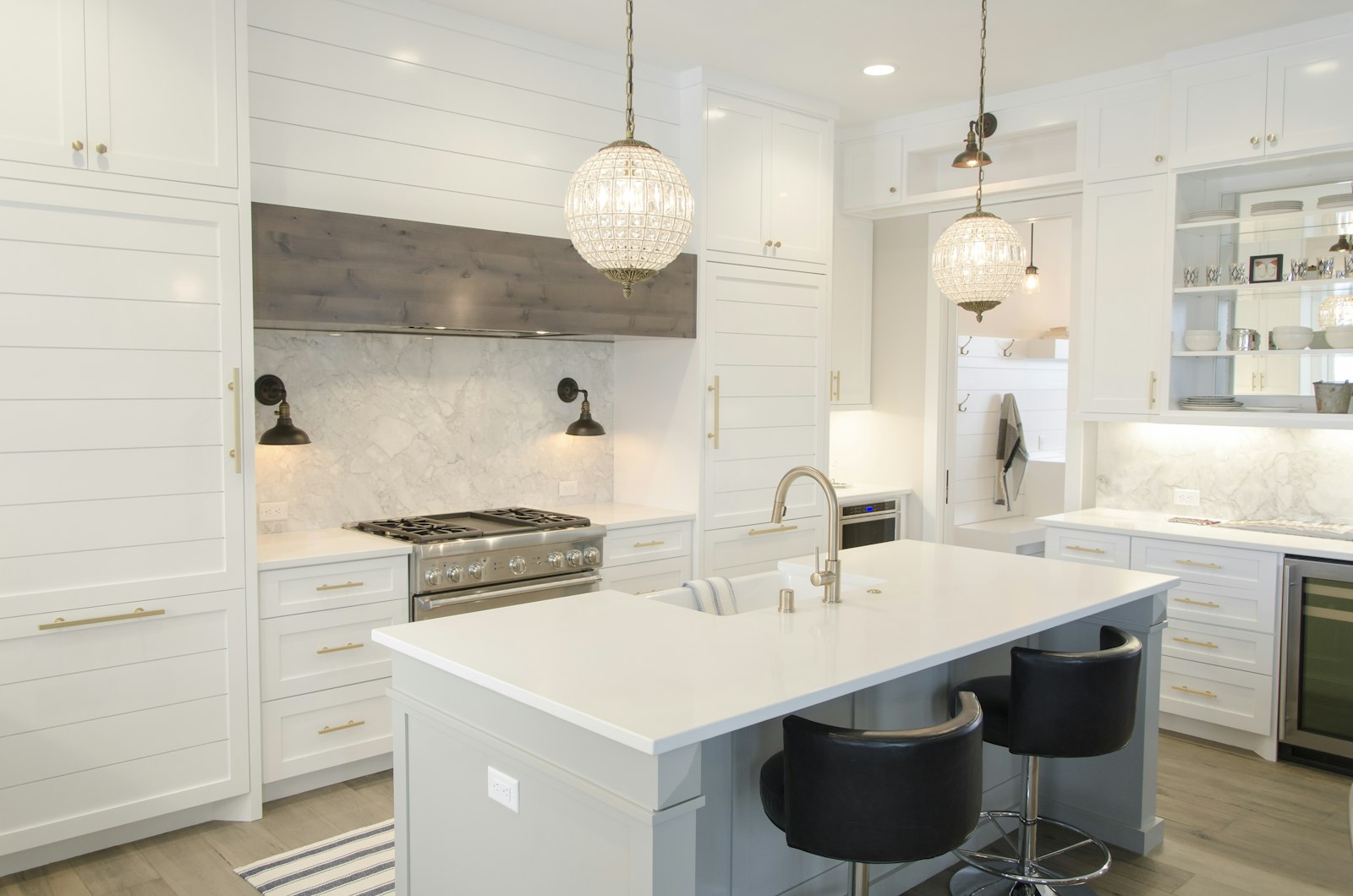 Finished farmhouse-style kitchen with white shaker cabinetry and crystal pendant lighting